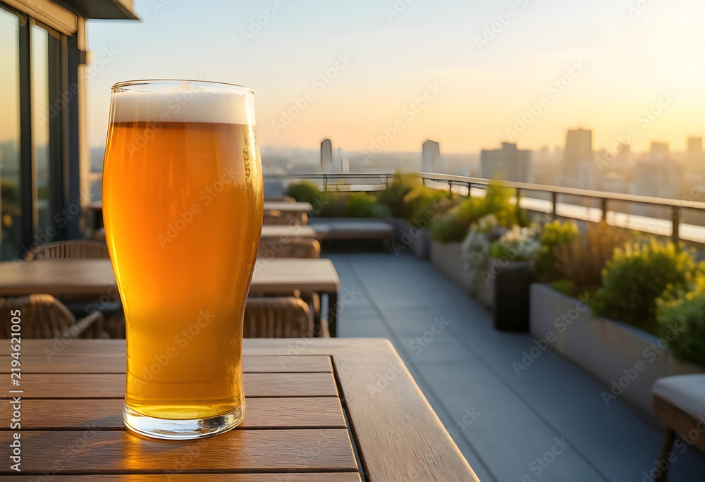 Obraz premium Happy hour and urban lifestyle, glass of cold beer on a rooftop terrace at sunset with city skyline view for relaxation and social leisure time