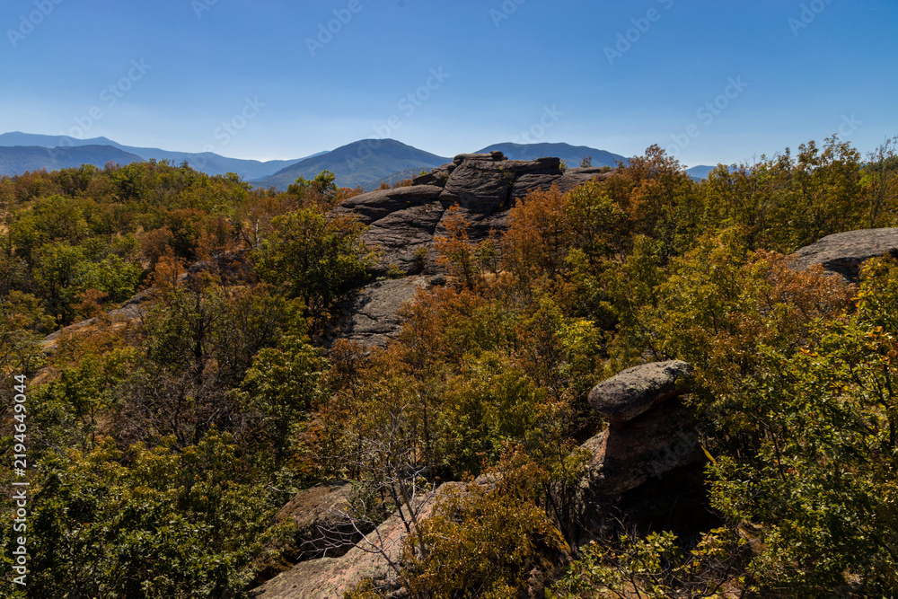 Fototapeta premium Belogradchik Rocks in Bulgaria, a spectacular natural rock formation featuring towering red sandstone and conglomerate cliffs shaped by erosion. The dramatic rock landscape