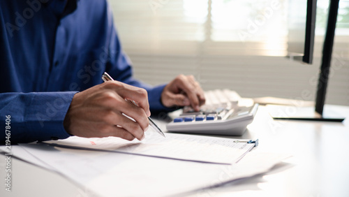 Fotografie Business professional reviews financial documents and calculates audit figures
