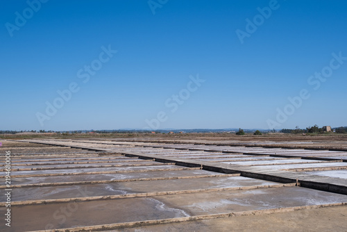 Konstfotografi salt pans with evaporation ponds and wooden borders under clear blue sky
