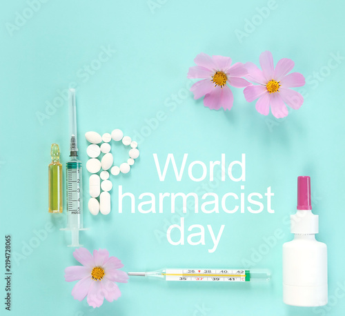 World Pharmacist Day greeting card. syringe, thermometer, flowers and pills on blue abstract background. symbol of medicine, drugs, health care. Flat lay. minimal style