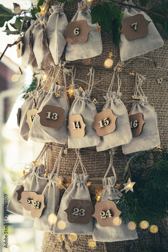Advent calendar garland. Homemade seasonal christmas decoration. Small surprise bags hang in a row.