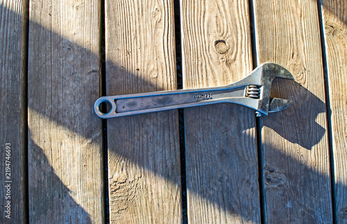 Metal wrench alone on weathered wooden deck