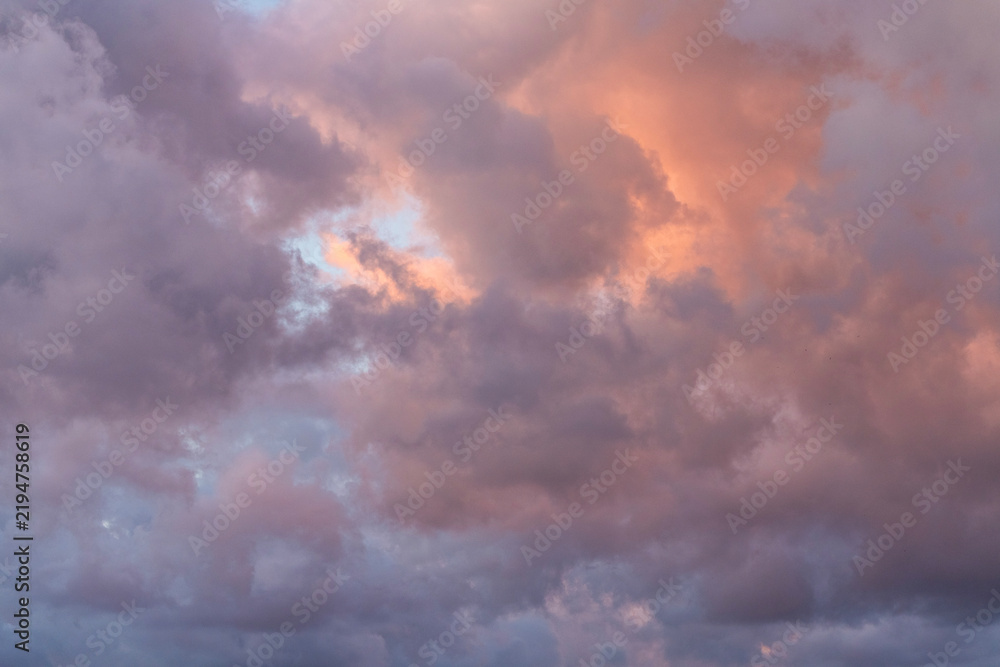 Fototapeta premium Close-up of a fluffy sunset orange clouds on the blue sky.