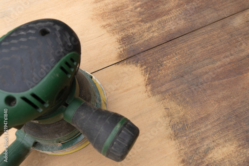 Obraz na plátně Electric orbital sander smoothing old wooden floor during home renovation