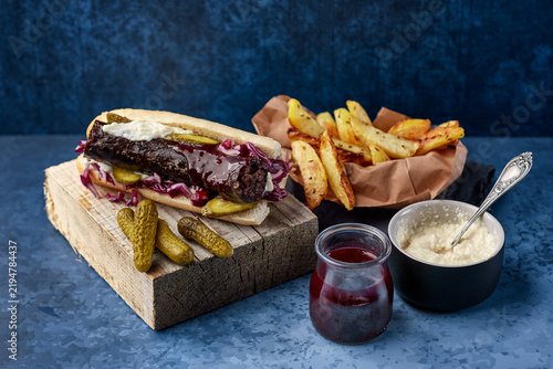 Obraz na plátne Blood sausage sandwich with fries and sauces