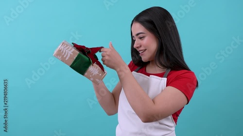 Young hispanic saleswoman showing a christmas gift