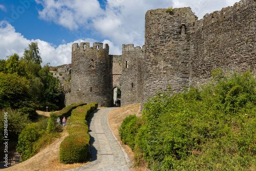 Photography Medieval stone town walls and gatehouse in Conwy, Wales, with a cobbled footpath