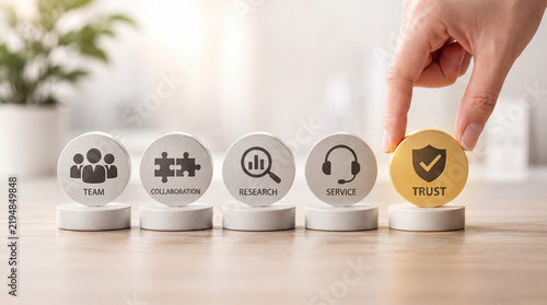 Conceptual Business Image Showing a Hand Placing a Gold Trust Icon Next to Team Collaboration Research and Service Icons Symbolizing Core Corporate Values and Reliable Customer Experience
