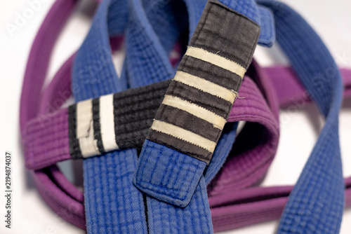 Brazilian Jiu-Jitsu Blue Belt with Four Stripes and Purple Belt on White Background