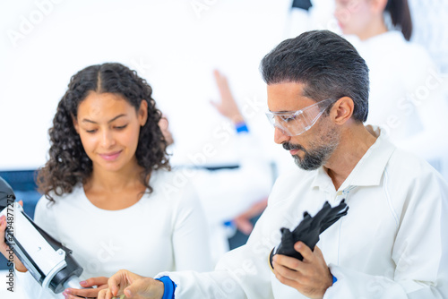 Fotografía Medical robotics development portrait of two focused engineers, one lowering a b