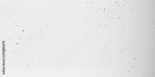 Vintage film grain texture on white background, subtle dust and speckle overlay, minimalist grunge paper effect for photo editing
