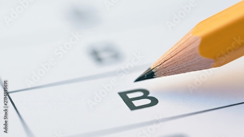 Student test answers graded with pencil on sheet, showing 'B' for evaluation.