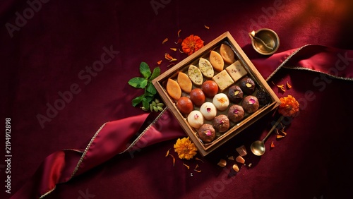 Assorted indian sweets arranged in a wooden gift box for festival celebration