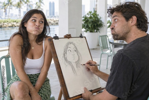 Artist Drawing Caricature Portrait Of Woman Making Funny Face On Patio
