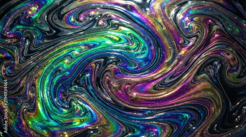 Abstract oil swirl with vibrant rainbow colors on a dark background