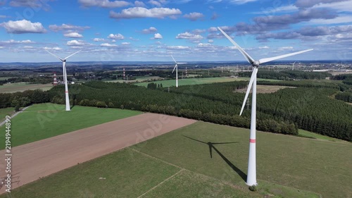 vue aérienne panoramique dans un parc éolien en Belgique, près de Bastogne et du village de Sibret. Les éoliennes sont entourées de champs agricoles ou de prairie pour l'élevage des bovins. 