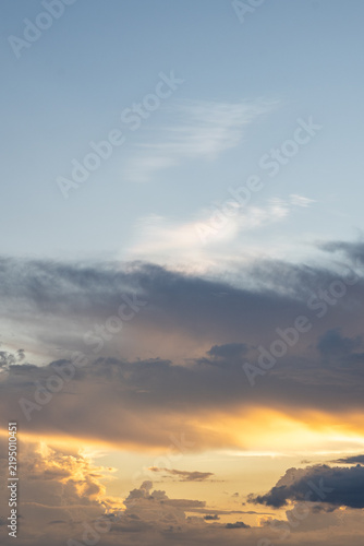 Peaceful sunset sky filled with golden sunlight glowing on serene cloud formations, bringing tranquil horizon atmosphere with copy space