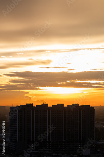 Silhouette building skyline glowing under golden sunset sky and cloud creating serene peaceful mood with urban city horizon copy