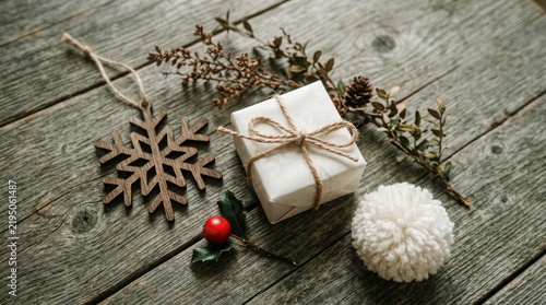 A rustic christmas scene presents pinecones and snowflake decorations on a weathered wooden surface evoking holiday cheer