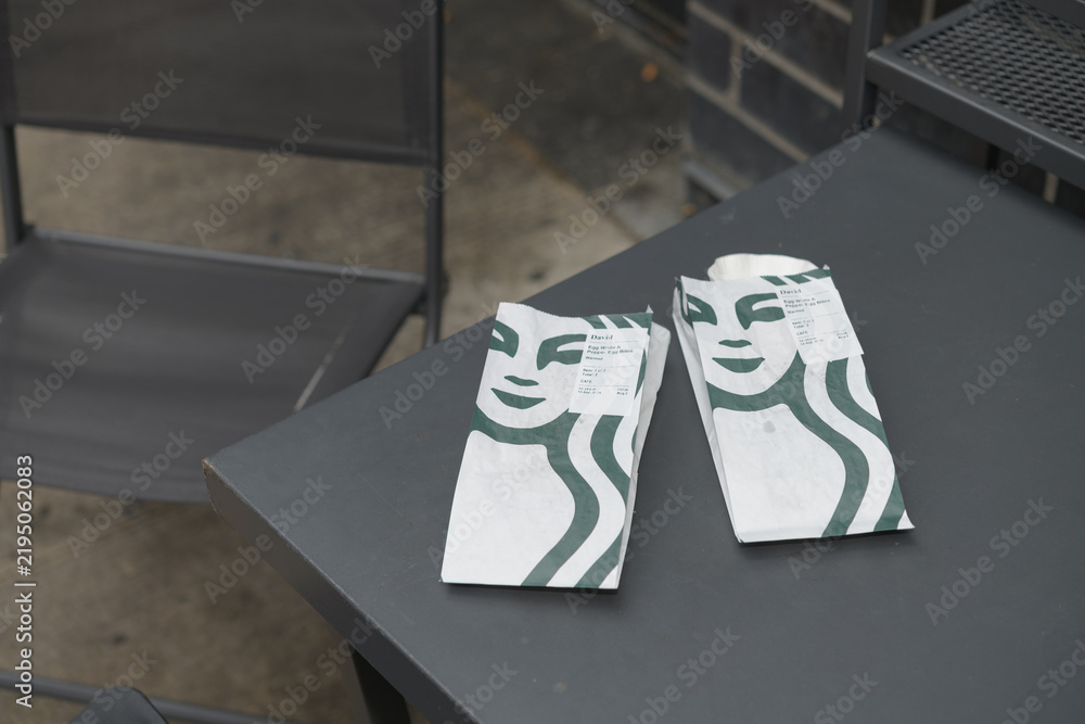 Obraz premium Starbucks bakery bags on a table outside a coffee shop in Toronto (Egg White & Roasted Red Pepper Egg Bites)