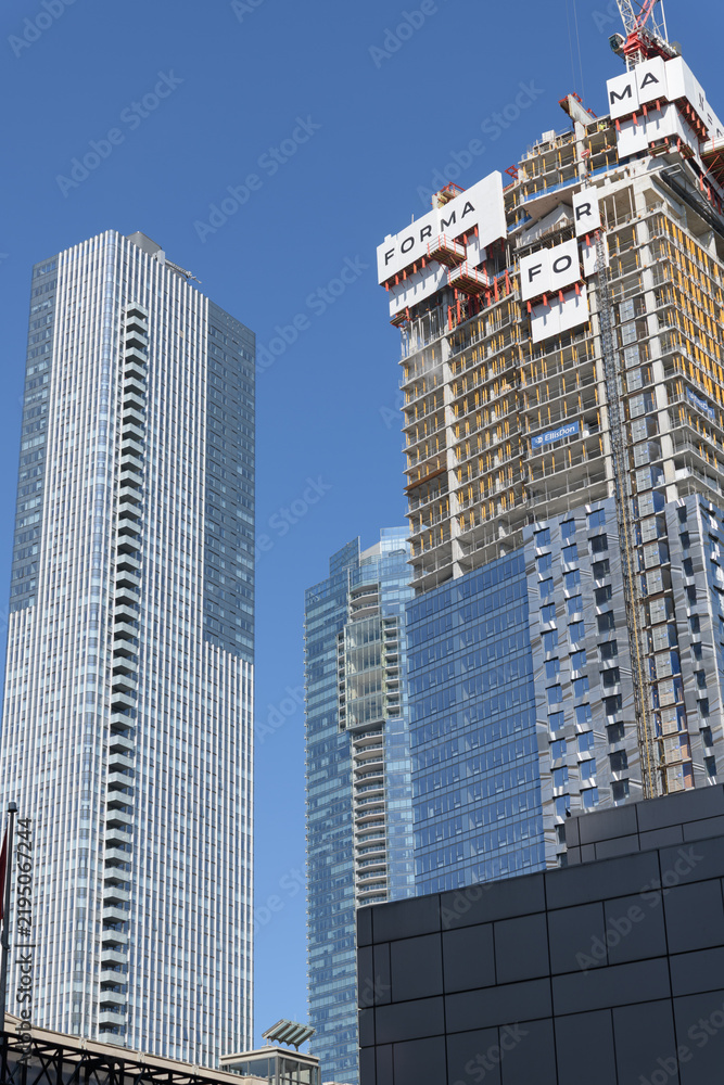 Obraz premium an upward view of the completed Thomson Reuters building (19 Duncan St) and construction of Forma Condos, East Tower, at 266 King St W, Toronto