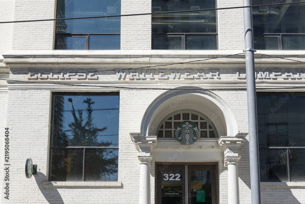 Obraz premium Starbucks Siren logo outside the historic Eclipse Whitewear Company at 322 King St W (at John), Toronto