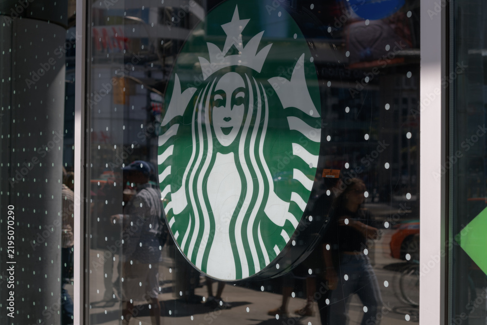 Obraz premium a commercial Starbucks “Siren” logo lightbox inside a window at coffee shop chain location, 10 Dundas St E, The Tenor, Toronto (Sankofa Square)