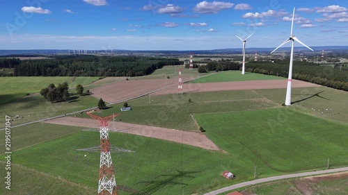 vue aérienne panoramique des éoliennes et des pylônes à haute tension électrique qui produisent et  transportent l'énergie dans la région de Bastogne, en Belgique, près du village de Sibret. 