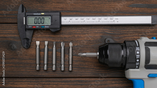 Fotografía Digital Caliper with Drill and Bits on Wooden Surface: Precision Tools for Accur