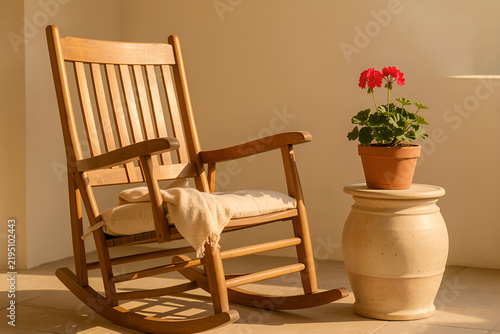 sunlit veranda rocking chair with a small ceramic table and geranium in warm light