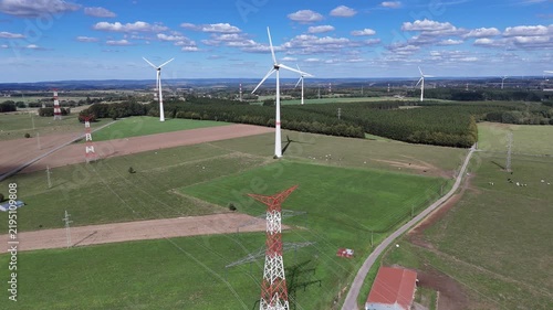vue aérienne panoramique dans un parc éolien en Belgique, près de Bastogne et du village de Sibret. Les éoliennes sont entourées de champs agricoles ou de prairie pour l'élevage des bovins. 