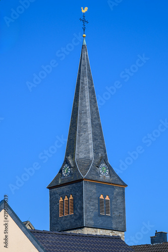 Bild auf Leinwand Church steeple with golden rooster weather vane against a blue sky