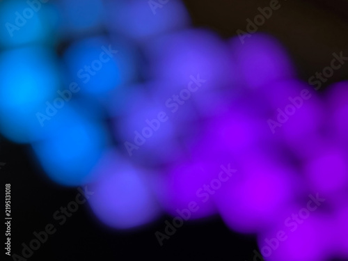 Abstract neon bokeh background with blue and violet blurry lights. 