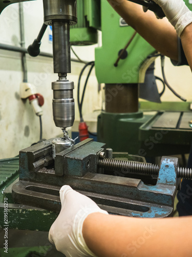 Obraz na płótnie Industrial Drill Press Machining Precision Electronic Component : Close-up vertical drill press precisely drilling metal electronic housing clamped in heavy bench vise in workshop