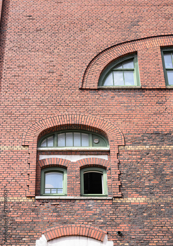 Картината върху платно Historic red brick industrial wall with arched windows.