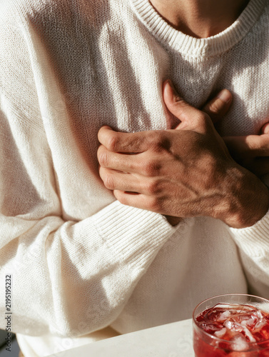 Chest pain human torso hand white sweater cocktail glass concern