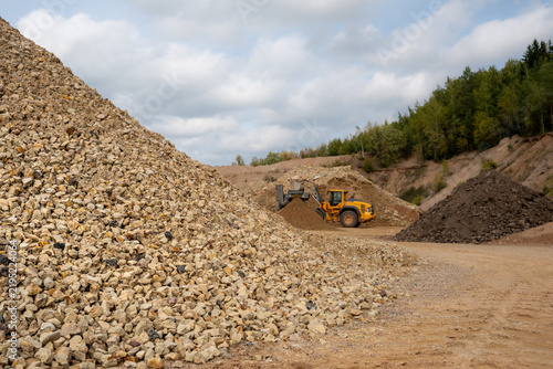 Large pile of crushed stone aggregate with wheel loader working in a quarry