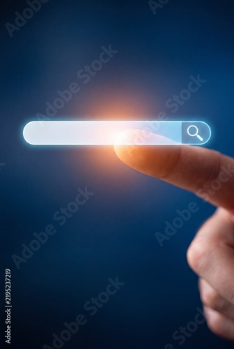 A finger points to a glowing search bar with a magnifying glass icon, symbolizing the start of an online search and the vast possibilities of the internet.