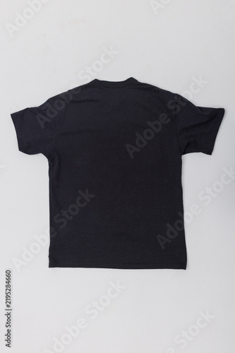 Fotografie Flat lay back view of a plain black cotton t-shirt isolated on a light background