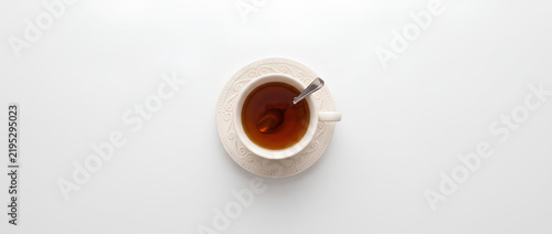 Top View of White Coffee Cup with Tea on White Surface.