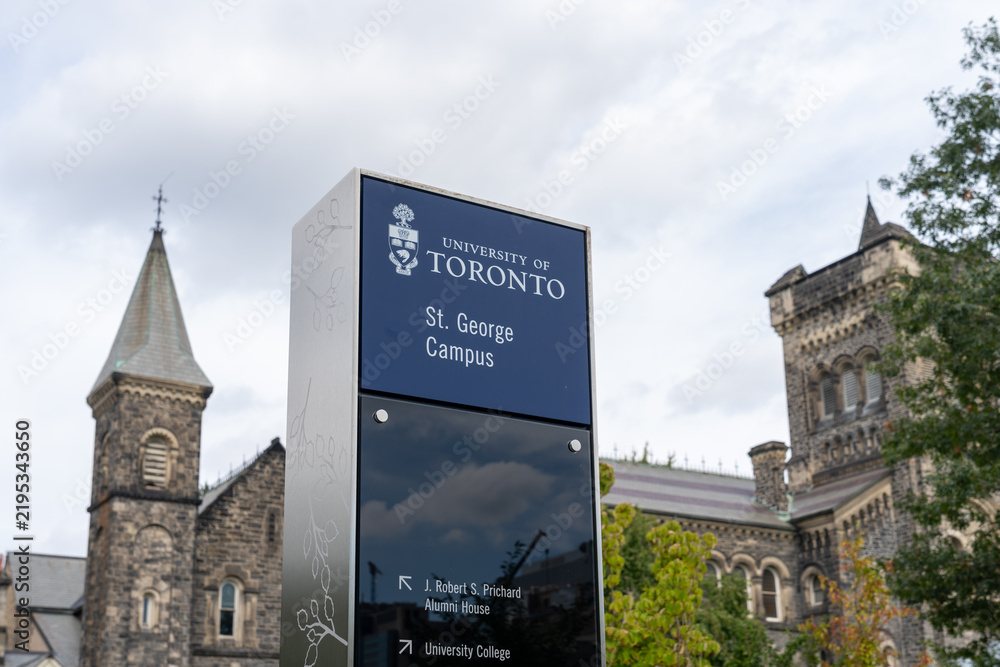 Fototapeta premium Toronto, Ontario, Canada - September 16, 2026: A campus directional sign with historic stone buildings in the background at the St George Campus of the University of Toronto in downtown Toronto, Ontar