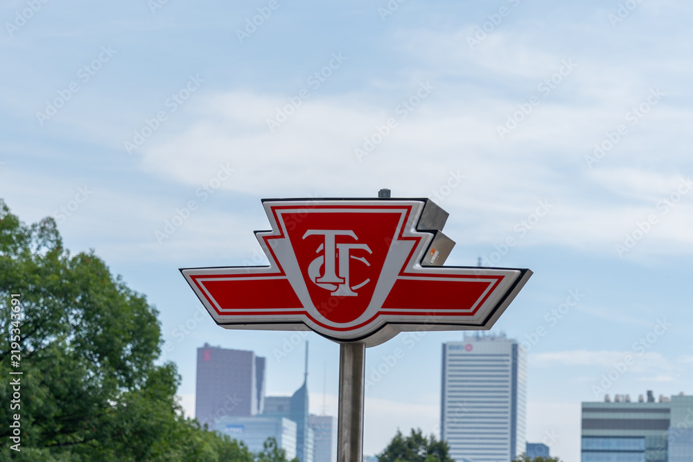 Obraz premium Toronto, Ontario, Canada - September 16, 2026: A logo sign of the Toronto Transit Commission (TTC) with buildings in the background in downtown Toronto, Ontario, Canada. 
