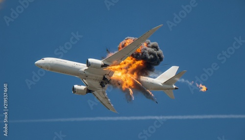 Konstfotografi An airplane in mid-air experiencing a catastrophic mid-section explosion with fire and smoke trails against a clear blue sky