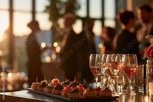 Catering buffet table with gourmet canapes and wine glasses at luxury cocktail party