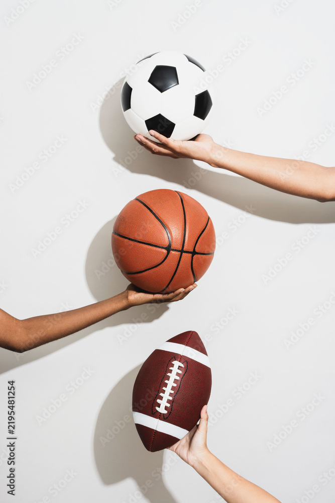 Fototapeta premium Hands holding various sports balls