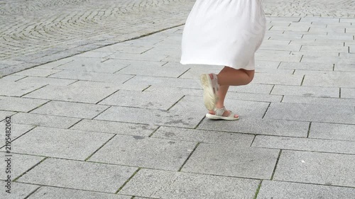 Little girl spinning around outdoors in a beautiful dress, with her dress flowing in the wind. Happy childhood moment, playful movement, slow motion.