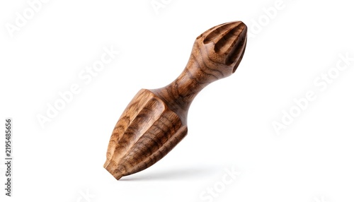 Wooden citrus reamer with carved flutes stands angled against a clean white background highlighting its texture.