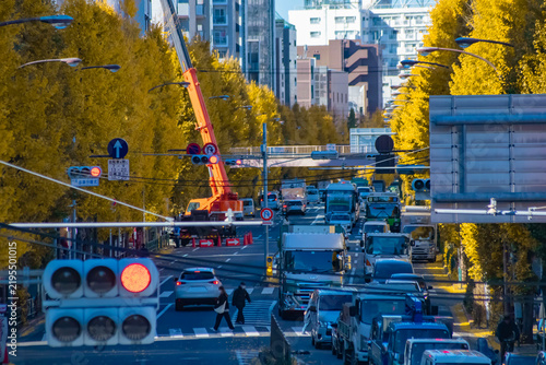 A cityscape of traffic jam at the yellow gingko street in Tokyo telephoto shot