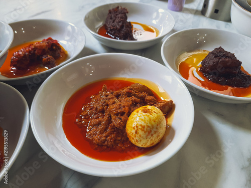 Samba Lado Tanak, an authentic Minangkabau dish of slowly cooked chili, coconut milk and spices served with boiled egg, accompanied by other Padang restaurant dishes.